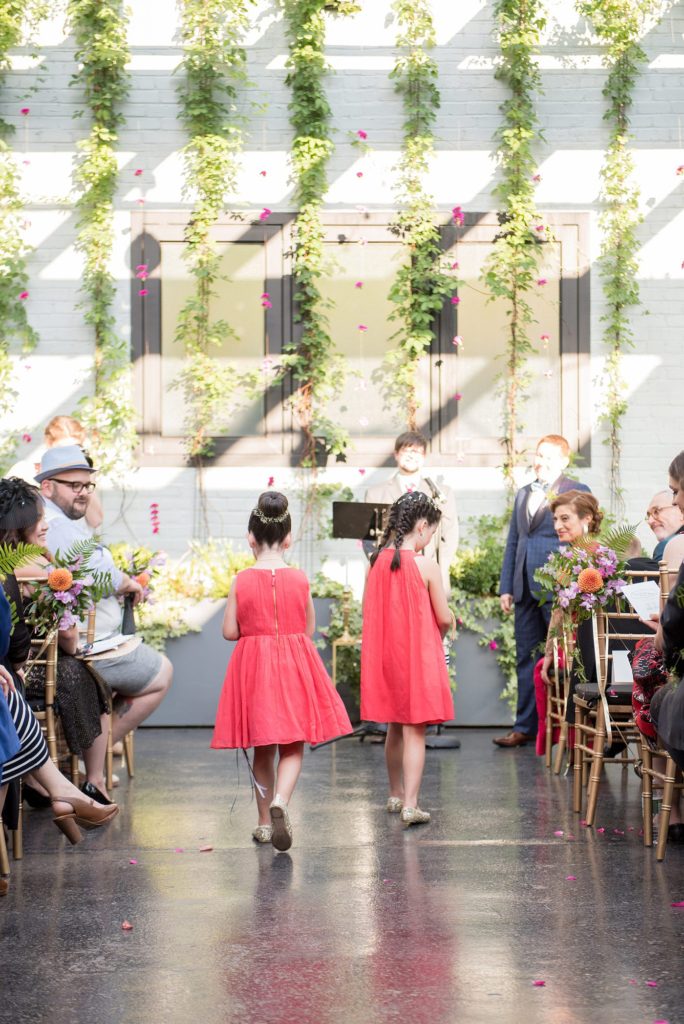 A 501 Union wedding with photos by Mikkel Paige Photography of the ceremony. The flower girls lined the aisle with flowers for the two brides.