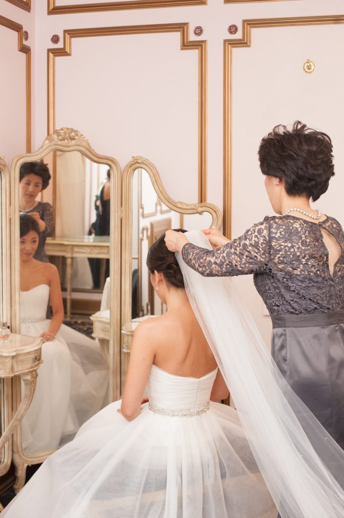 The bride's mother helps put her veil on at her Crystal Plaza Wedding in New Jersey with photos by Mikkel Paige Photography.