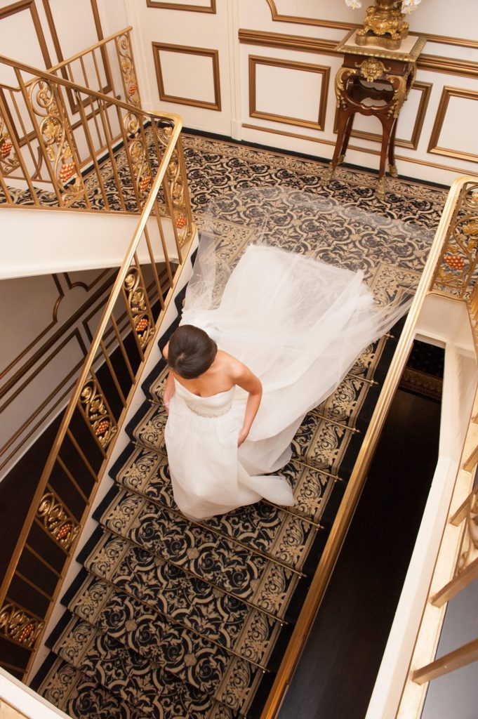 The bride walked down the stairs at her luxury wedding to see her groom at the Crystal Plaza venue in New Jersey. Photos created by Mikkel Paige Photography.