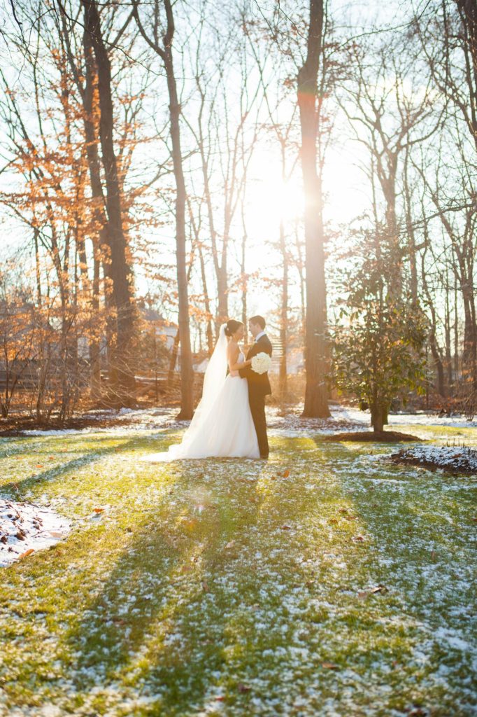The bride and groom take photos with Mikkel Paige Photography at their luxury Crystal Plaza Wedding in New Jersey with a light dusting of snow on the ground.