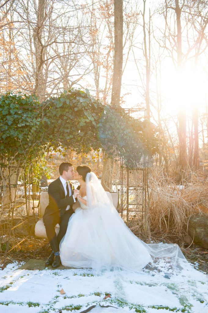 The bride and groom take photos with Mikkel Paige Photography at their luxury Crystal Plaza Wedding in New Jersey with a light dusting of snow on the ground.