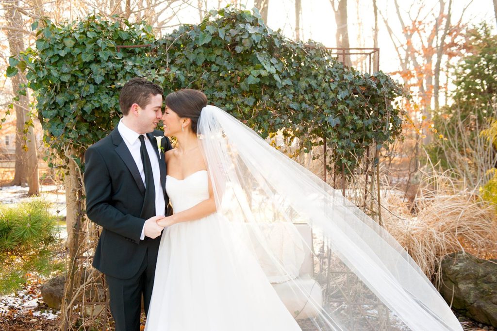 The bride and groom take photos with Mikkel Paige Photography at their luxury Crystal Plaza Wedding in New Jersey with a light dusting of snow on the ground.