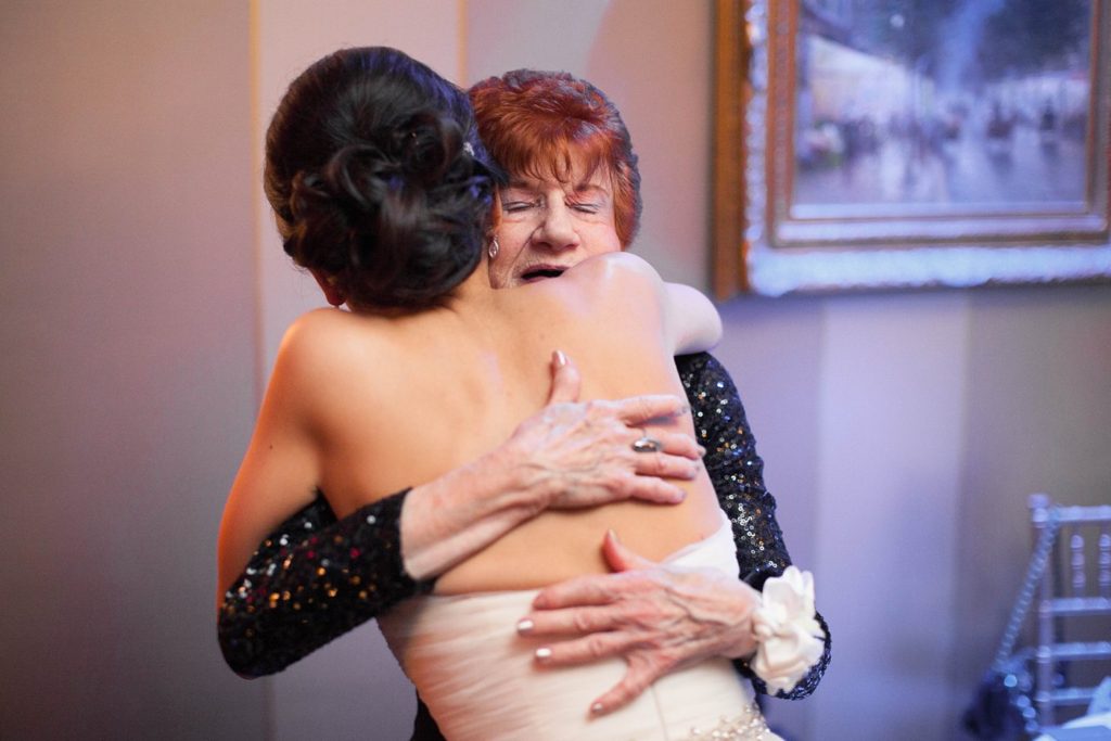 Picture of the bride hugging the groom's grandmother during a winter wedding at the Crystal Plaza in NJ. Photos by Mikkel Paige Photography.