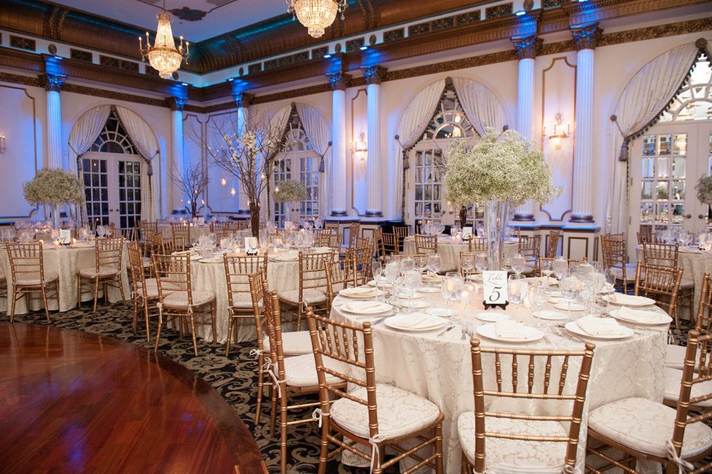 The reception room was covered in Baby's Breath centerpieces alternated with willow branches and orchids during a winter reception for a wedding at the Crystal Plaza in NJ. Photos by Mikkel Paige Photography.