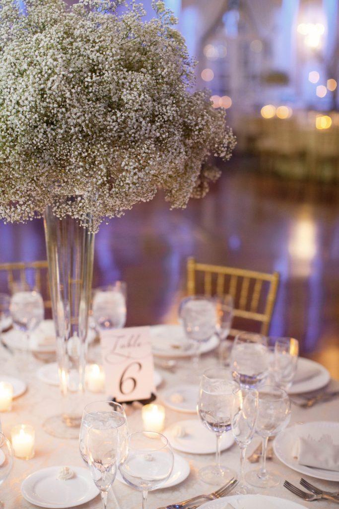 The reception room was covered in Baby's Breath centerpieces alternated with willow branches and orchids during a winter reception for a wedding at the Crystal Plaza in NJ. Photos by Mikkel Paige Photography.