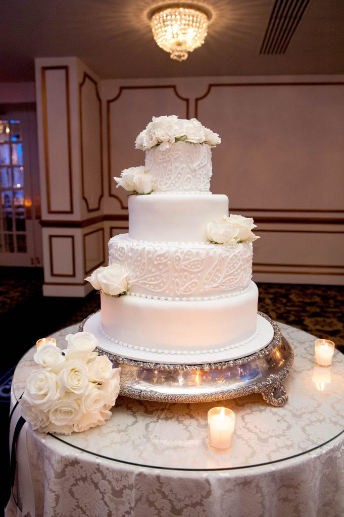 A white tiered fondant and buttercream cake was perfect for a winter reception at a Crystal Plaza wedding in NJ. Photos by Mikkel Paige Photography.
