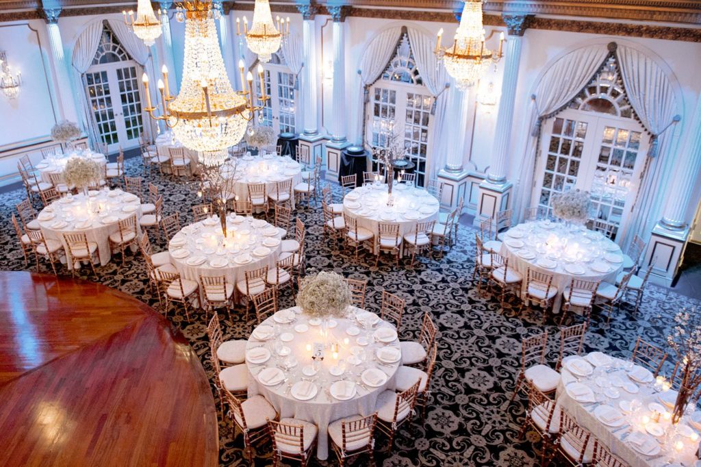 The reception room was covered in Baby's Breath centerpieces alternated with willow branches and orchids during a winter reception for a wedding at the Crystal Plaza in NJ. Photos by Mikkel Paige Photography.