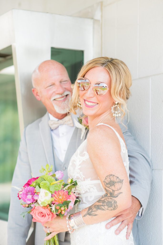 Fuquay-Varina wedding at Highgrove Estate in North Carolina with photos by Mikkel Paige Photography. The bride carried a tropical bouquet by Flowers on Broad Street and wore cute heart sunglasses for a photo.