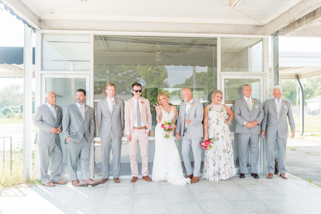 Fuquay-Varina wedding at Highgrove Estate in North Carolina with photos by Mikkel Paige Photography. The bride carried a tropical bouquet by Flowers on Broad Street and they had a bridesdude in a pink suit, with a bridesmaid in a floral gown.