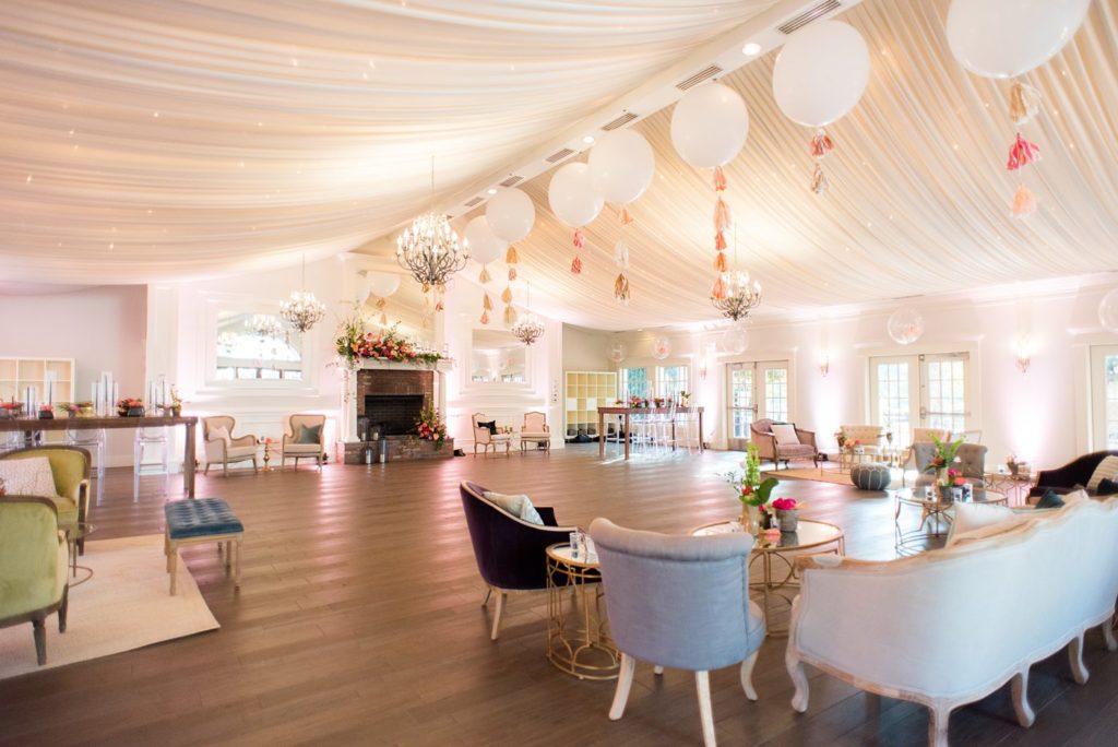 Fuquay-Varina wedding at Highgrove Estate in North Carolina with photos by Mikkel Paige Photography. Planning by A Southern Soiree. Lounge furniture rentals from Greenhouse Picker Sisters and huge balloons and tissue paper tassels adorning the ceiling.