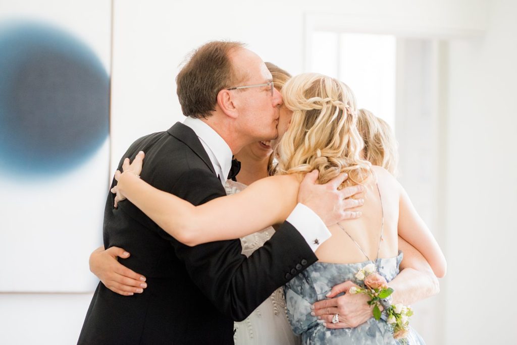 The bride hugs her family and father at her Hudson Valley wedding in upstate New York, photographed by Mikkel Paige Photography. Planning by The Union Studio at Southwood Estate.