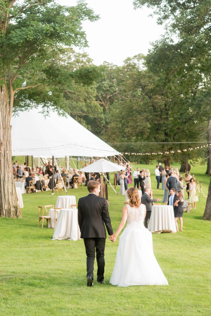 Bride and groom rejoin their cocktail hour during golden hour captured by Mikkel Paige Photography at Southwood Estate overlooking the Hudson River in the valley, in upstate New York.