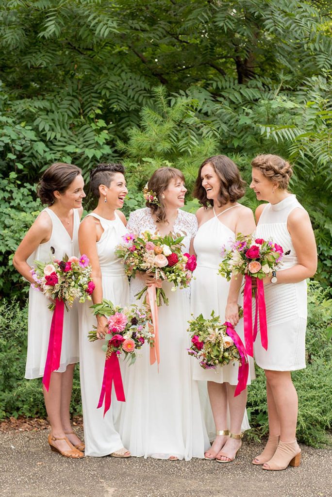 Prospect Park Boathouse wedding in Brooklyn, New York. Bridal party photos by Mikkel Paige Photography with everyone dressed in white with colorful bouquets by Sachi Rose Designs.