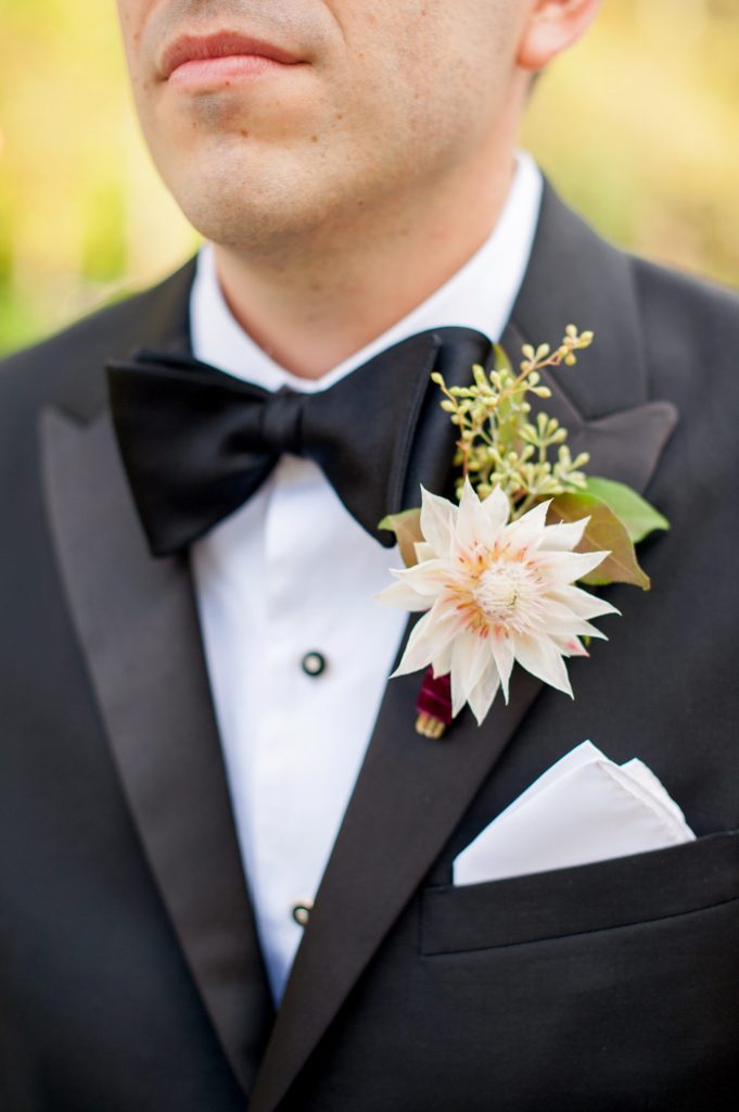 Mikkel Paige Photography photo of the groom at a Prospect Park Boathouse wedding in Brooklyn, New York. Boutonniere created by Sachi Rose Designs.