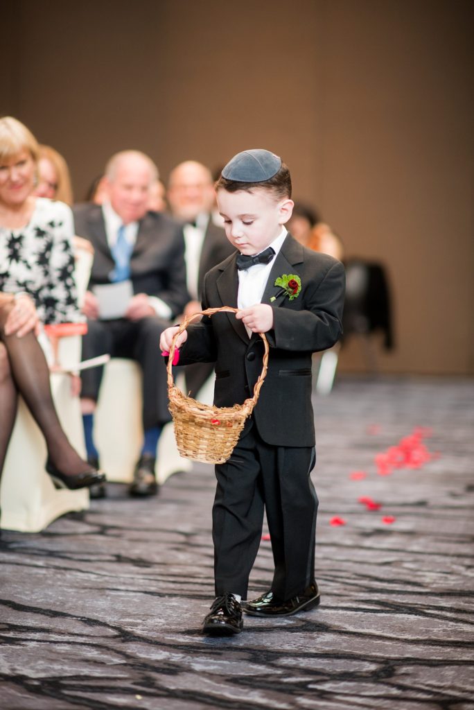 Photos of a ring bearer during the ceremony of an April celebration by Mikkel Paige Photography of a W Hoboken wedding.