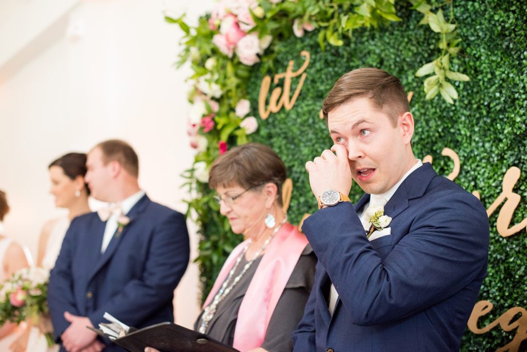 The groom gets tearful as his bride walks down the aisle at a ceremony at a wedding venue in Raleigh, NC. Photo by Mikkel Paige Photography, luxury and destination photographer.