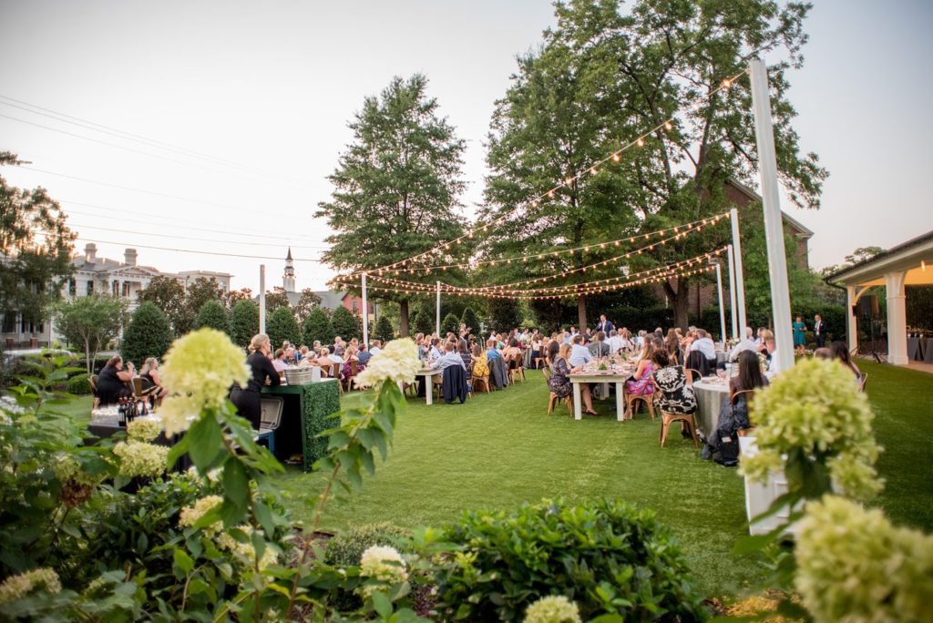 Dinner outside on the lawn with string lights at an upscale wedding in downtown Raleigh. Photographed by Mikkel Paige Photography with planning by C&D Events.