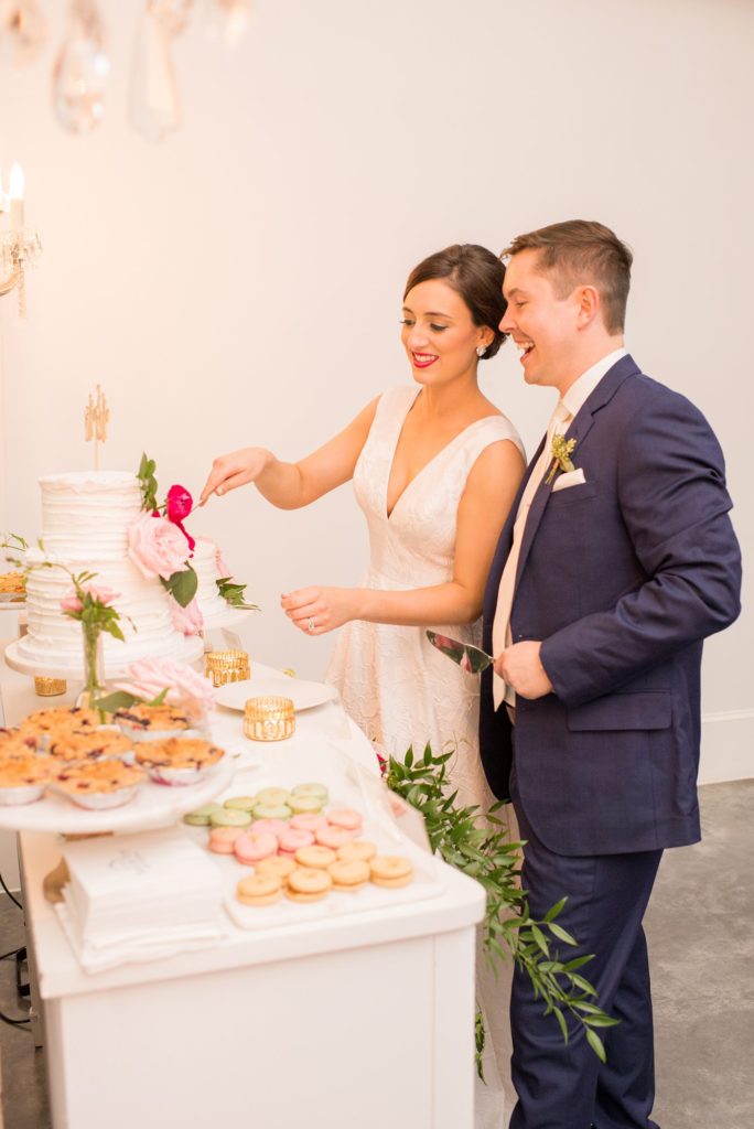 The bride and groom cut their cake, by Sugar Euphoria, at their wedding in downtown Raleigh, NC, photographed by Mikkel Paige Photography.