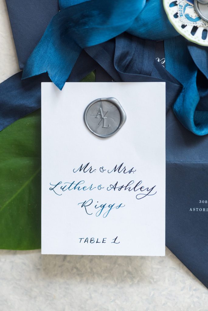 Flat lay styling for luxury weddings and events by Mikkel Paige Photography. This blue calligraphy and silver wax seal were an escort card for a destination wedding at Casa de Campo in the Dominican Republic.