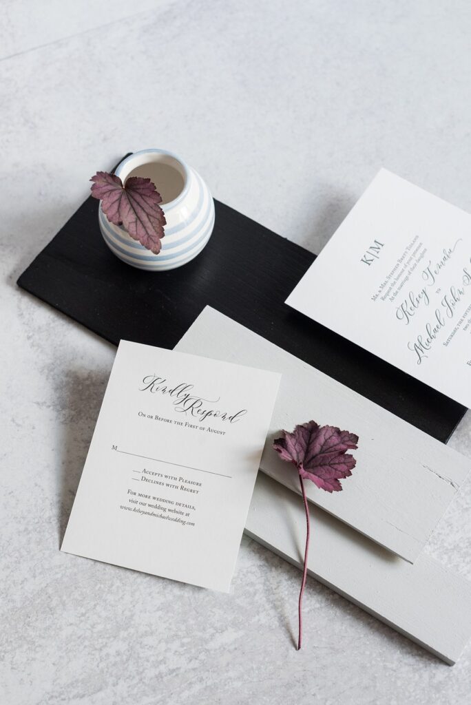 An elegant and timeless flat lay stationery photo with two begonia leaves and strong invitation shadow.