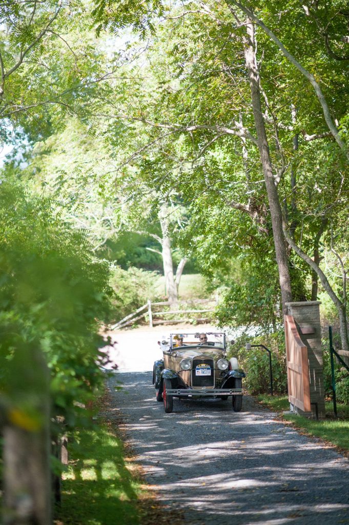 Hamptons wedding photographer captures two grooms for a same sex wedding at a private home. Images by Mikkel Paige Photography of the groom and his father in a vintage car.
