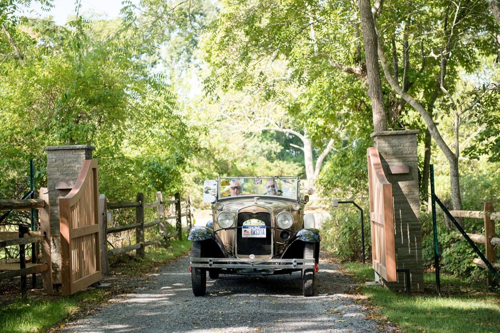 Hamptons wedding photographer captures two grooms for a same sex wedding at a private home. Images by Mikkel Paige Photography of the groom and his father in a vintage car.