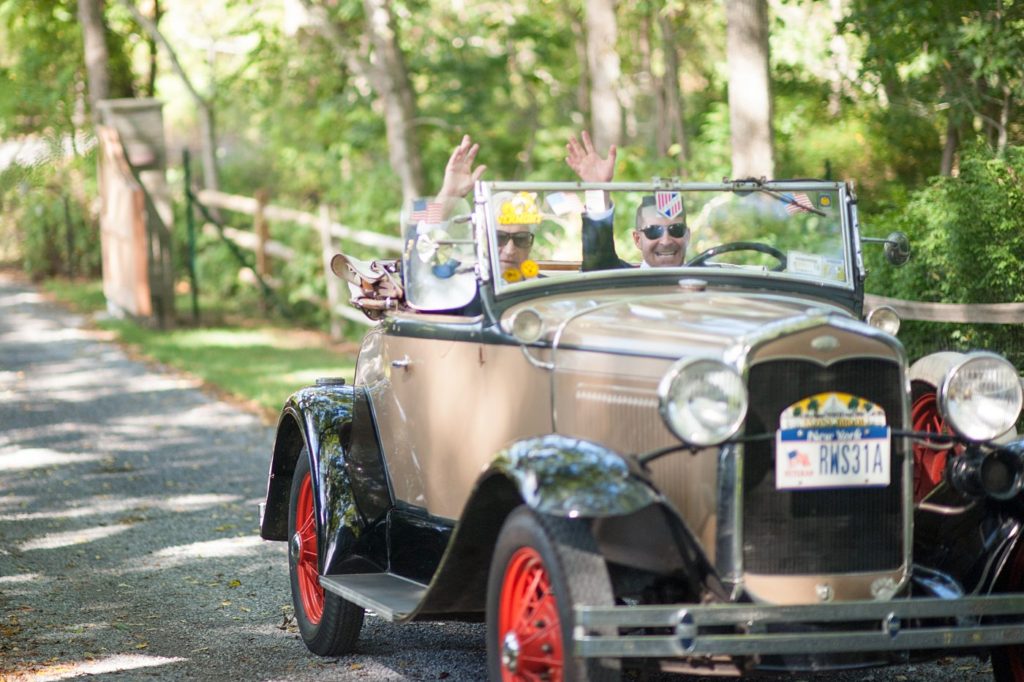 Hamptons wedding photographer captures two grooms for a same sex wedding at a private home. Images by Mikkel Paige Photography of the groom and his father in a vintage car.