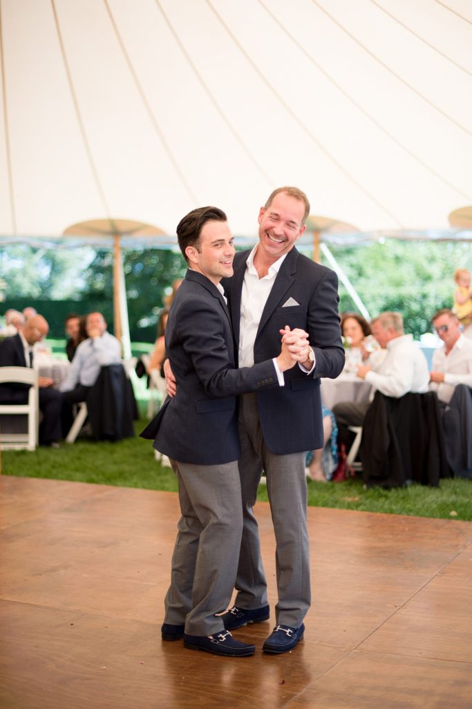 Hamptons wedding photographer captures two grooms for a same sex wedding at a private home with a tented outdoor reception. Images by Mikkel Paige Photography.