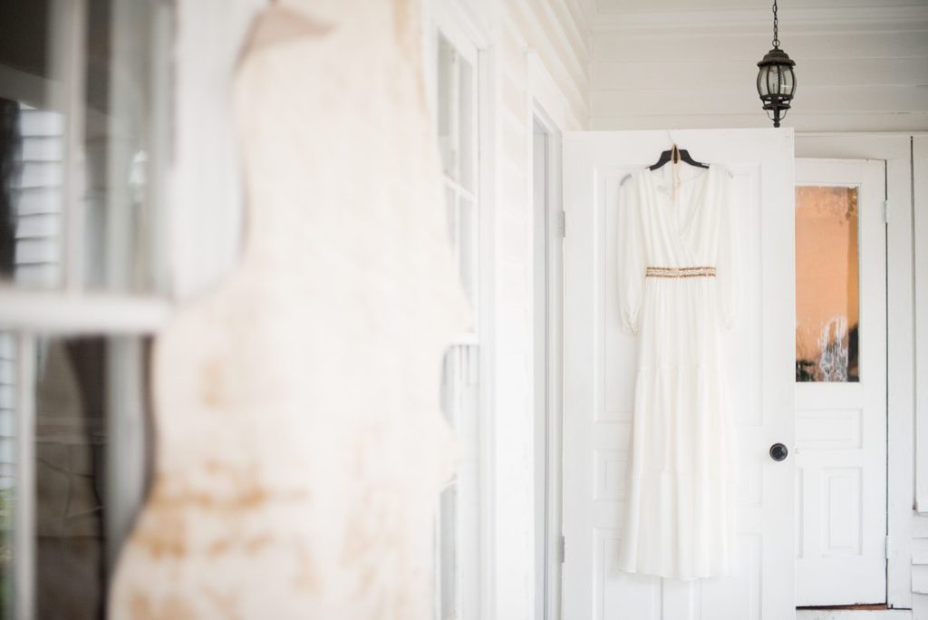 Small wedding in North Carolina with photos by Mikkel Paige Photography. The bride and groom got married in an intimate setting at historic Leslie-Alford Mims House in Cary. The bride wore a bohemian ethereal gown with long sleeves and gold belt detail.