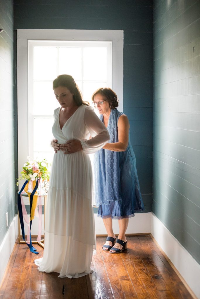 Small wedding in North Carolina with photos by Mikkel Paige Photography. The bride and groom got married in an intimate setting at historic Leslie-Alford Mims House in Cary. The bride wore a bohemian ethereal gown with long sleeves and gold belt detail.