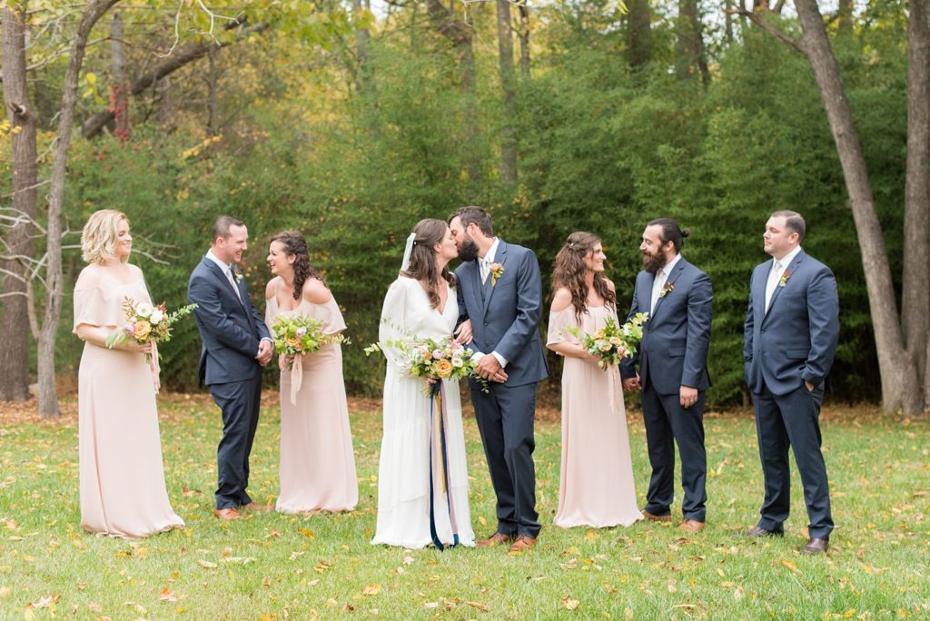 Small wedding in North Carolina with photos by Mikkel Paige Photography. The bridesmaids held fall flower bouquets and wore light pink gowns while the groomsmen wore blue suits.