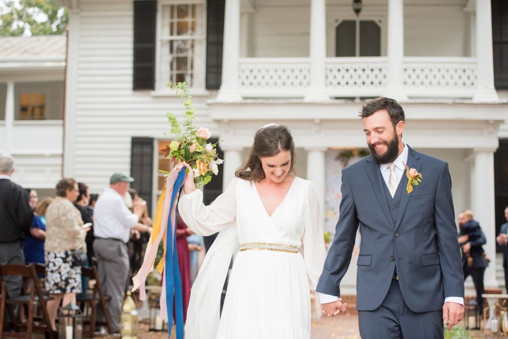 Small wedding in North Carolina with photos by Mikkel Paige Photography. The bride and groom walked back down the aisle in front of historic Leslie-Alford Mims House in Cary.