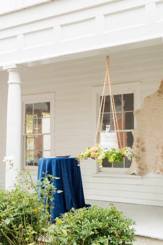 Small wedding in North Carolina with photos by Mikkel Paige Photography. The intimate reception for less than 50 people had a cake suspended from the ceiling on a bed of fall flowers with a husky dog cake topper for the bride and groom.