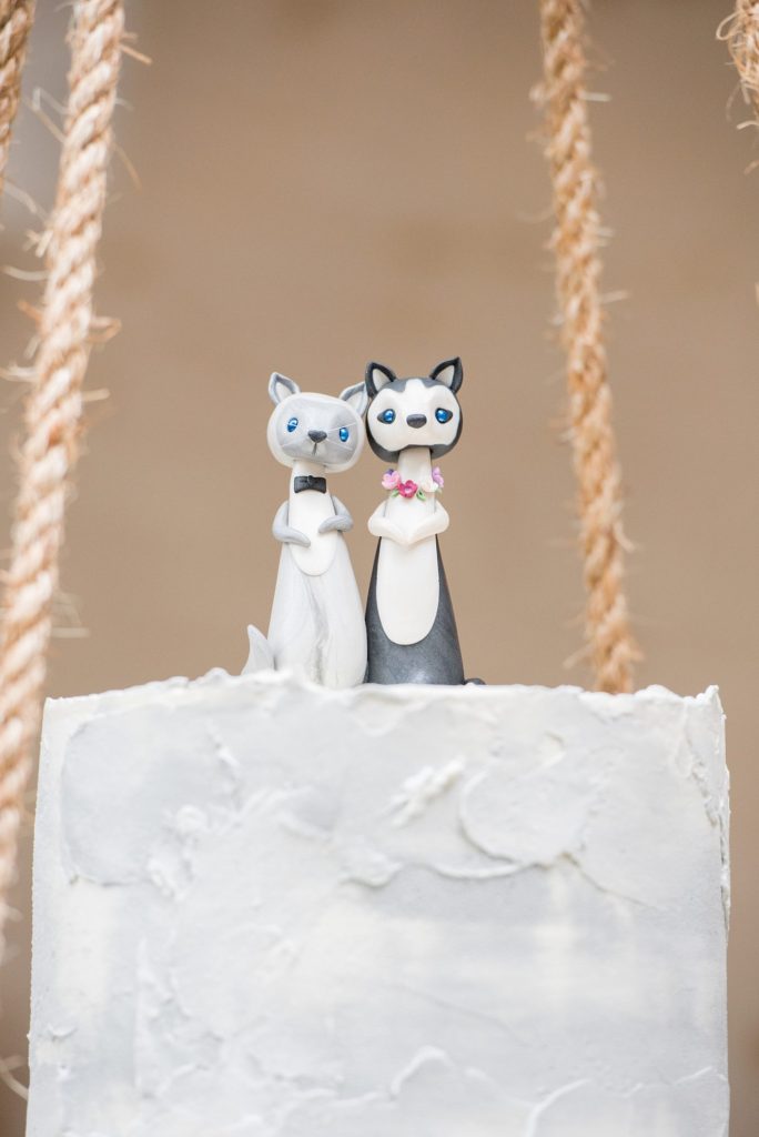 Small wedding in North Carolina with photos by Mikkel Paige Photography. The intimate reception for less than 50 people had a cake suspended from the ceiling on a bed of fall flowers with a husky dog cake topper for the bride and groom.