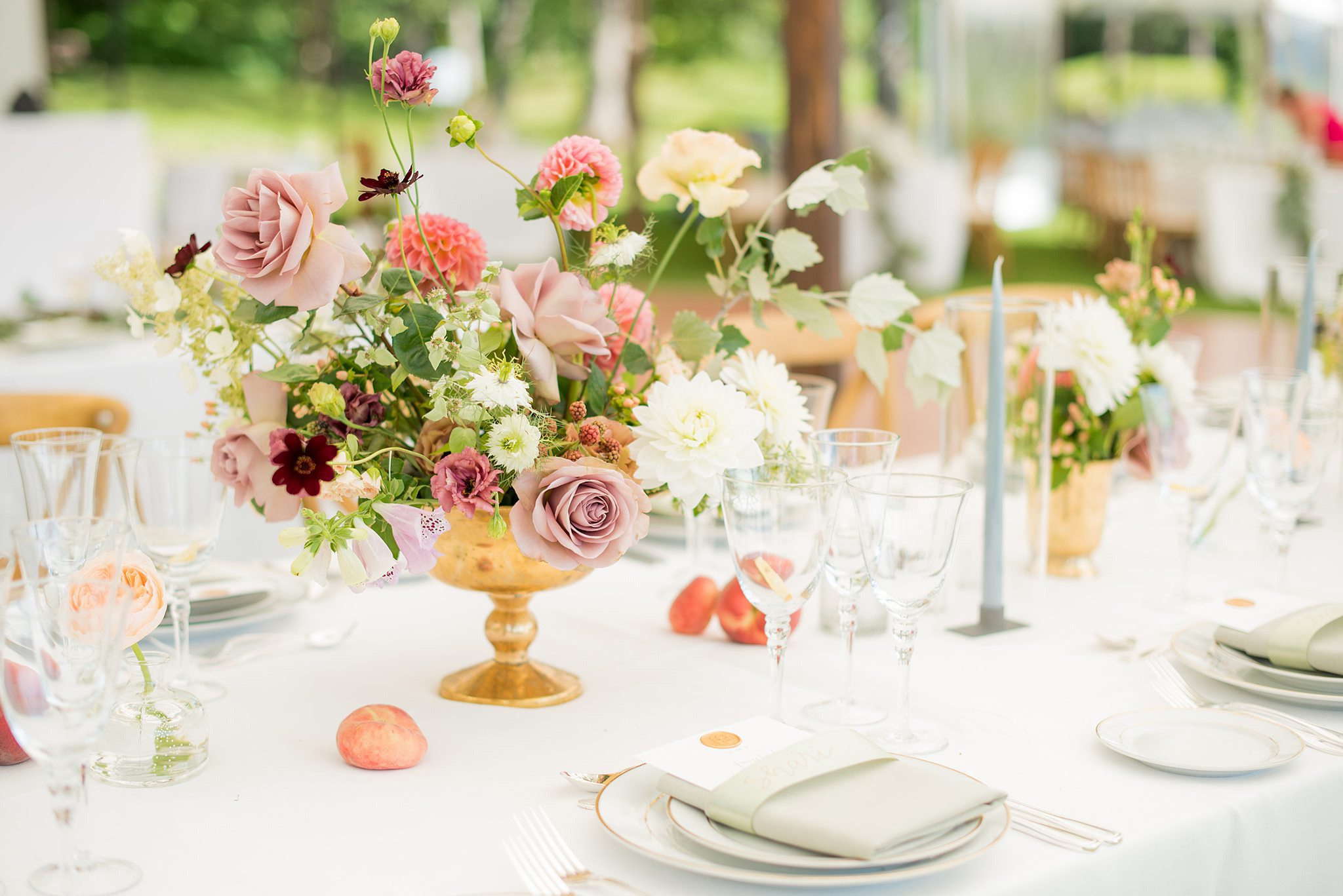 Luxury destination wedding in the Hudson Valley of New York, with lush table decor and floral centerpieces under a Sperry tent. Photography by Mikkel Paige.