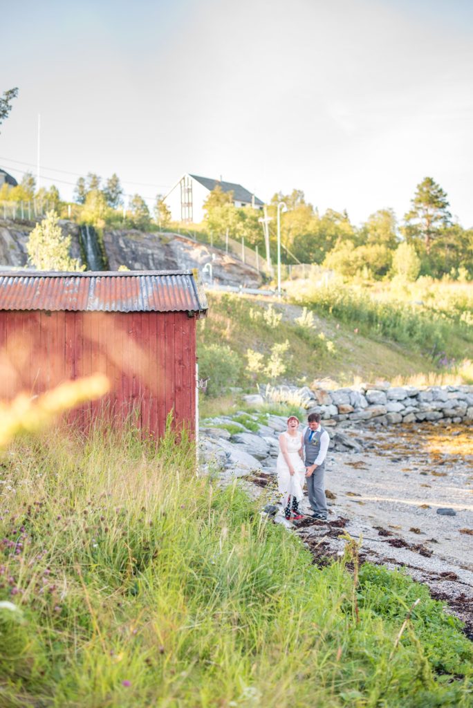Norway Destination wedding photos by Mikkel Paige Photography in the Arctic Circle. The bride and groom had fun with pictures on the shore by a fjord.