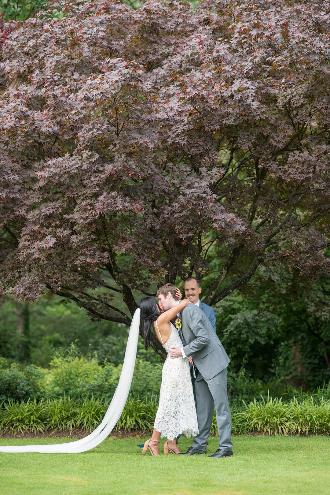 The bride and groom kiss amongst flowers in the park after their small outdoor ceremony. Wedding pictures by Mikkel Paige Photography. #mikkelpaige #raleighwedding #raleighNC #smallwedding