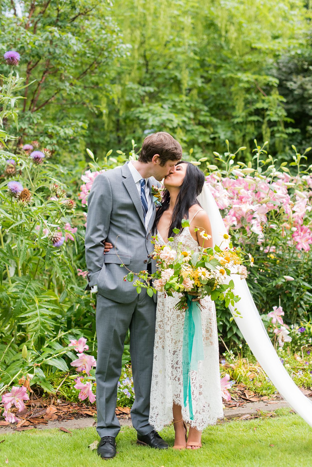 The bride and groom kiss amongst flowers in the park after their small outdoor ceremony. Wedding pictures by Mikkel Paige Photography. #mikkelpaige #raleighwedding #raleighNC #smallwedding