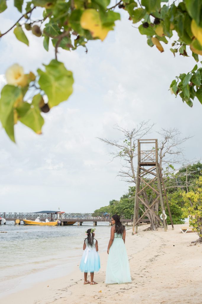 The flower girls walk on the beach at a wedding in Jamaica at Iberostar resort. Photo by Mikkel Paige Photography.