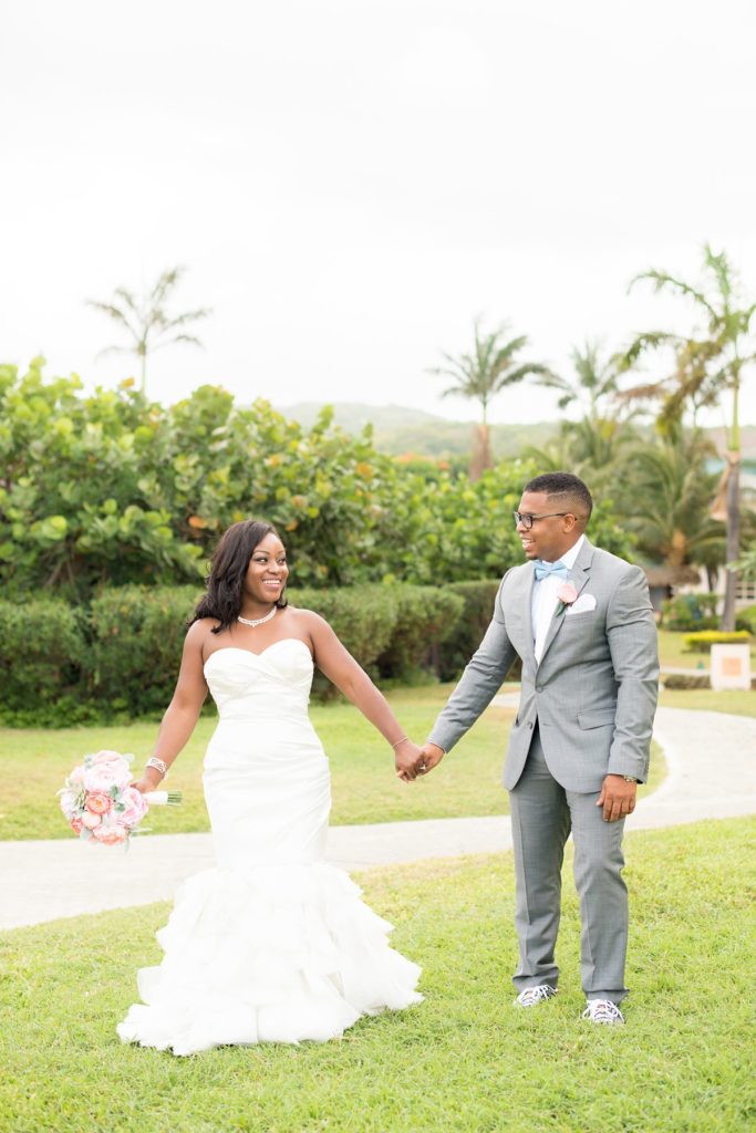 The bride and groom with palm trees at Iberostar resort in Jamaica for their wedding day. Photo by Mikkel Paige Photography.