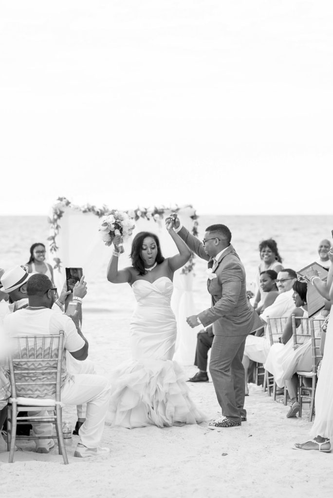 The bride and groom dance down the aisle at their Jamaica wedding at Iberostar resort with an oceanfront ceremony.