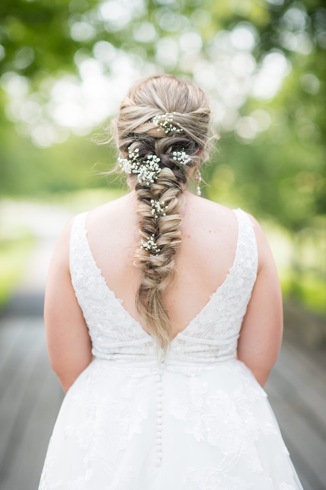 The bride had baby's breath in her fish tail style braid for her wedding day look. Photos by Mikkel Paige Photography. #mikkelpaige #mountaidafarm #charlottesvillewedding