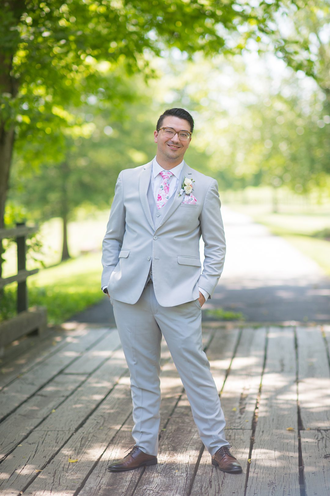 Groom in a grey suit with a pink floral tie and pocket square for a small wedding in Charlottesville, VA during COVID. Photos by Mikkel Paige Photography.