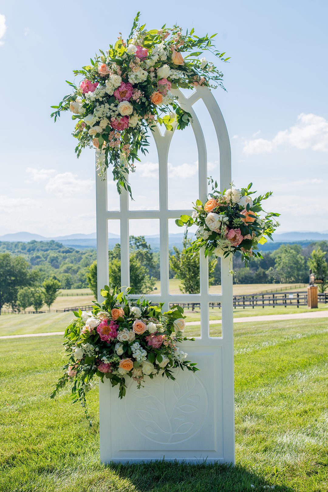 Small wedding ceremony details, in windows that were custom made and decorated with summer flowers. Photos by Mikkel Paige Photography at The Lodge at Mount Ida Farm in Charlottesville, VA. Planning by Mary Elizabeth Events. #mikkelpaige #Charlottesvillewedding #picturesqueceremony