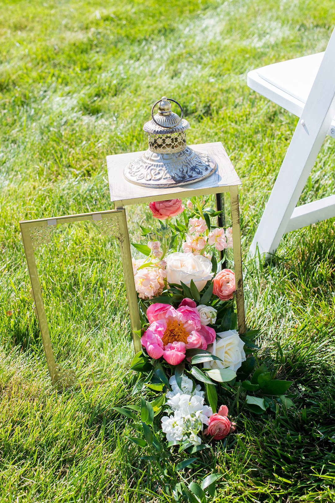 Small wedding ceremony flowers spilling out of a lantern.