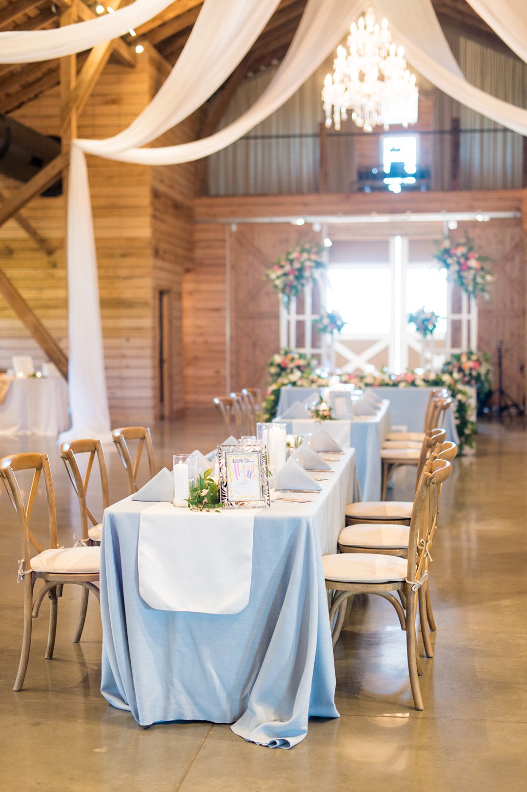 Blue linens with white runners and flowers lined the tables at a small wedding reception at The Lodge at Mount Ida Farm in Charlottesville, VA. Photos by Mikkel Paige Photography. #mikkelpaige #charlottesvillewedding #CharlottesvilleVA #MountaIdaFarm #weddingreception