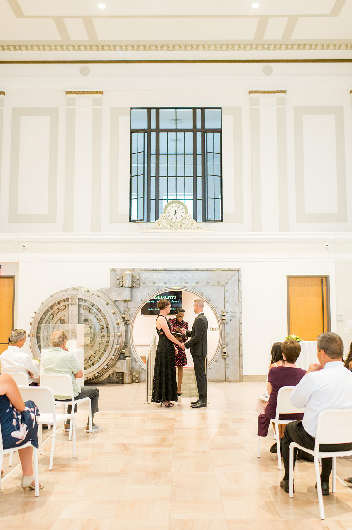 Wedding ceremony at an art museum, in front of an old safe.