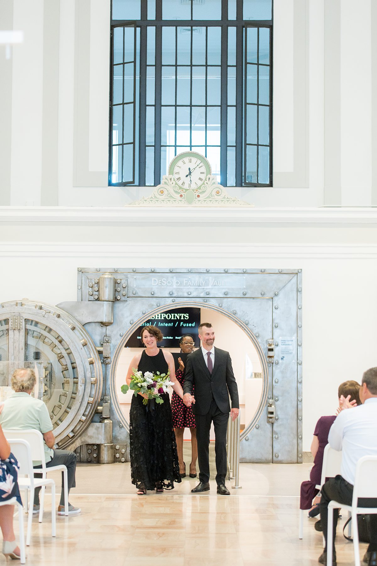 Wedding ceremony at an art museum, in front of an old safe.