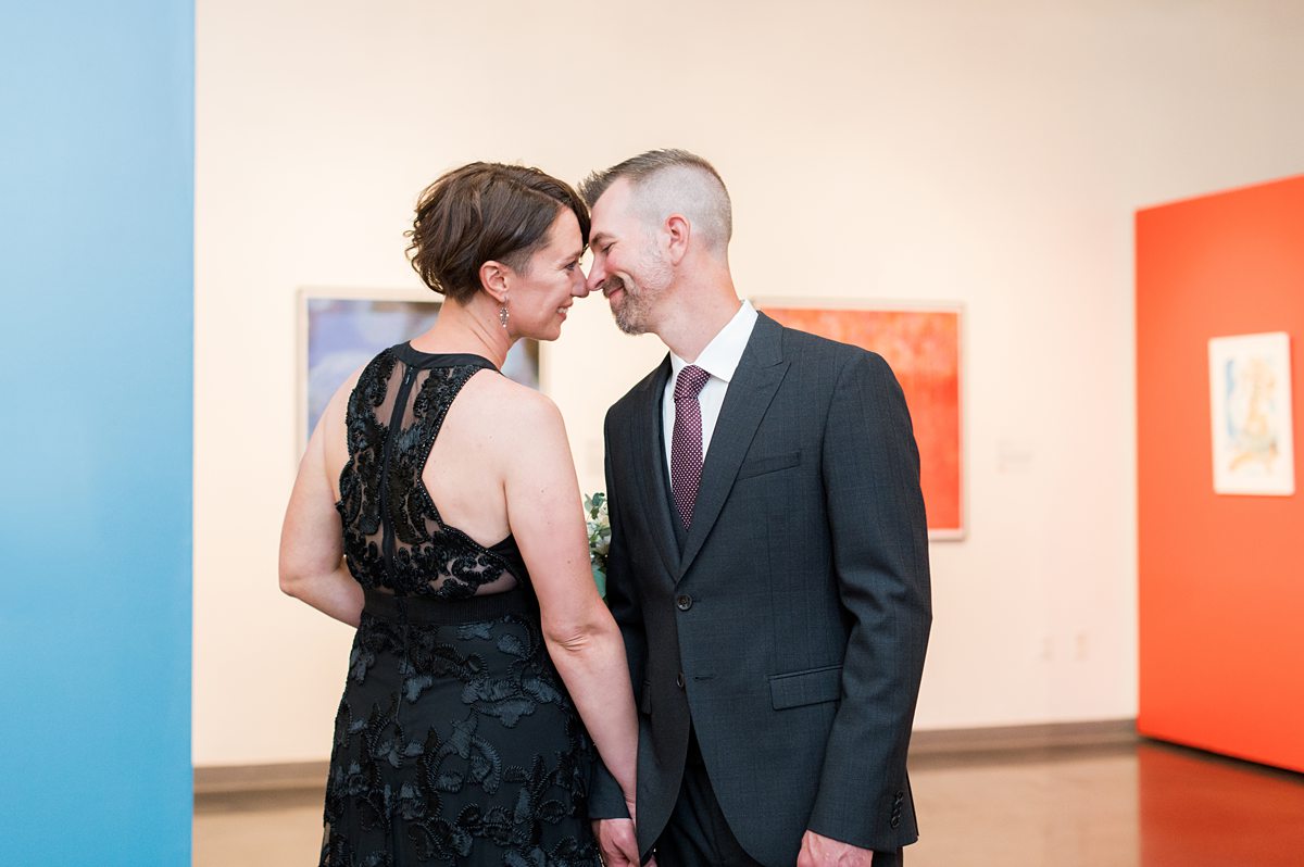 Bride and groom in formal wear at an art museum.