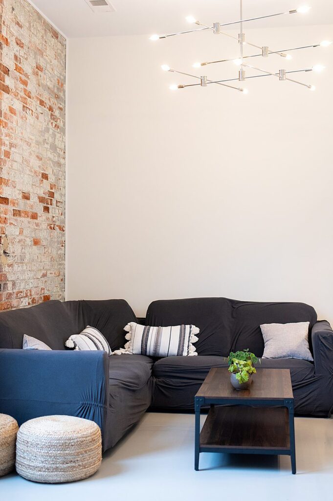 Grey couch in a white and brick room, groom's suite, at The Graham Mill in NC.